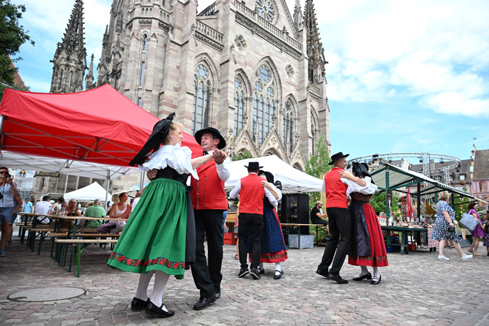 Personnes en costumes traditionnels alsaciens dansant place de la Réunion à Mulhouse