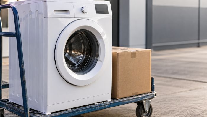 Illustration symbolique d’un lave-linge et d’un carton sur un chariot de manutention