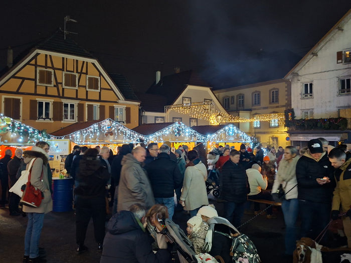 Chalets illuminés et visiteurs du marché de Noël de Dannemarie en 2025